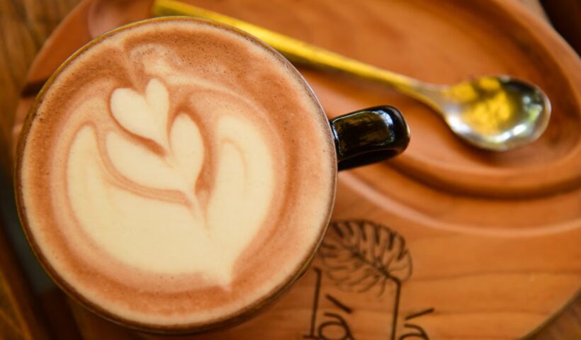 Latte art coffee on a wooden tray in a cafe