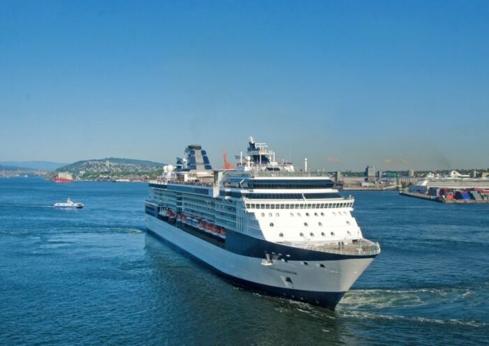 A large cruise ship sailing through calm waters under a clear blue sky