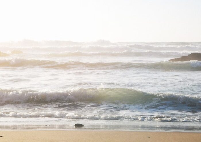 Waves rolling onto a sandy beach at sunset