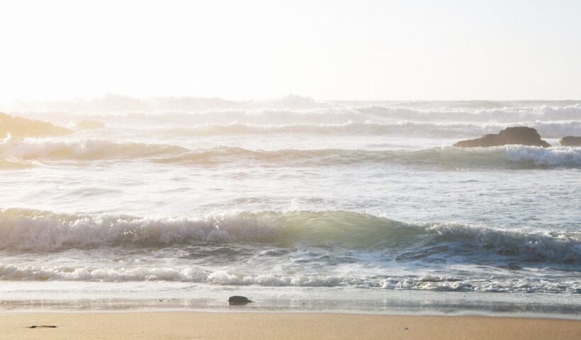 Waves rolling onto a sandy beach at sunset