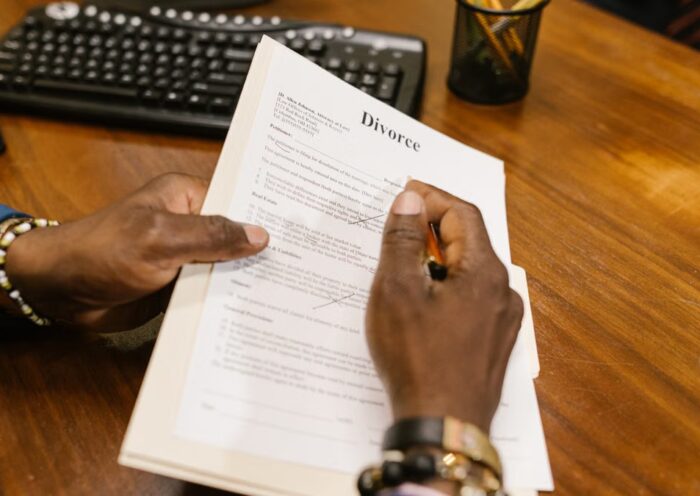 Person signing divorce documents at an office desk