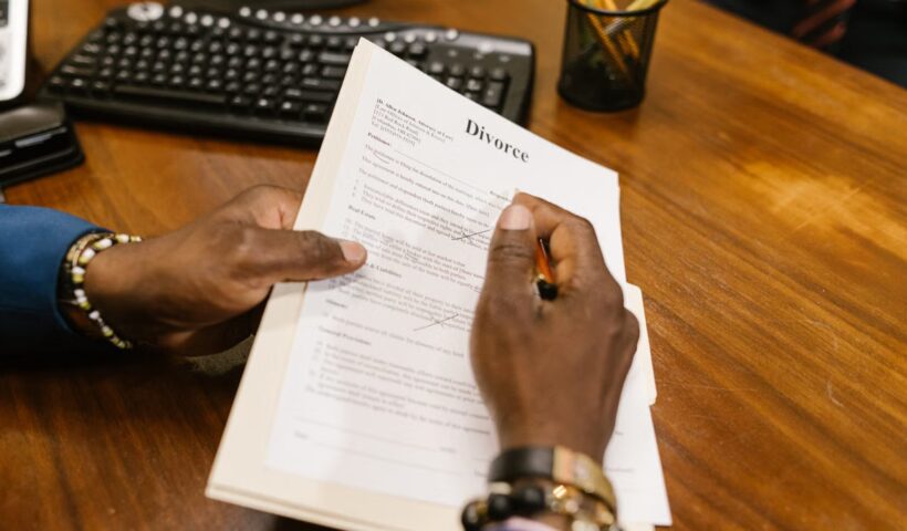 Person signing divorce documents at an office desk