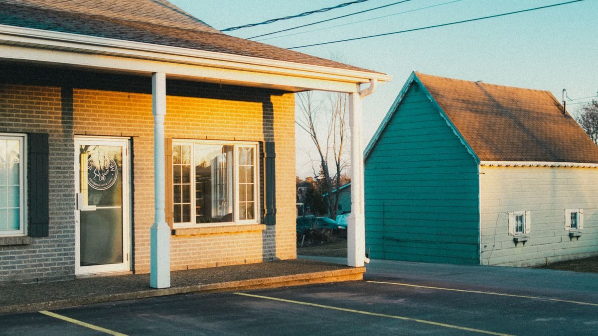 A serene image of suburban buildings and parking lot during golden hour