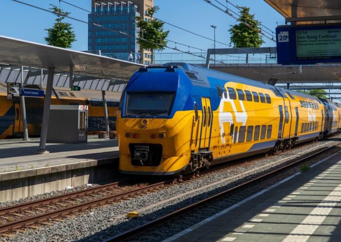 Colorful blue and yellow train arriving at Utrecht Central Station in the Netherlands on a sunny day