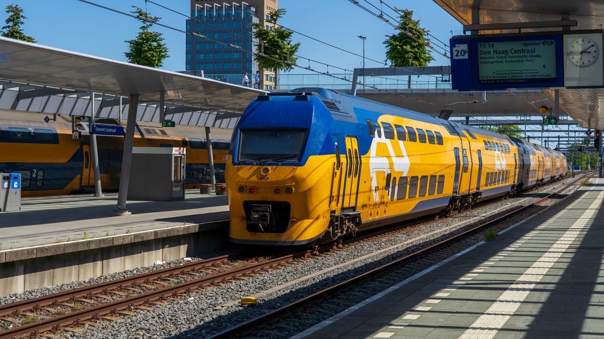 Colorful blue and yellow train arriving at Utrecht Central Station in the Netherlands on a sunny day