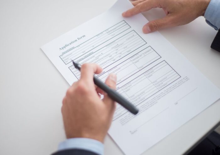 Close-up of a business professional reviewing an application form at a desk