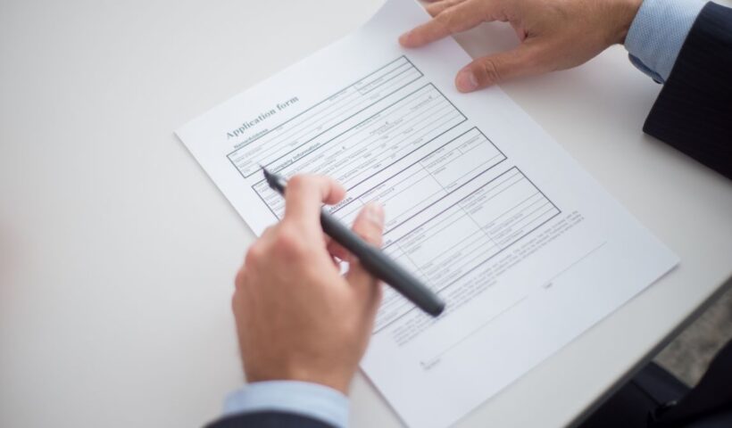 Close-up of a business professional reviewing an application form at a desk