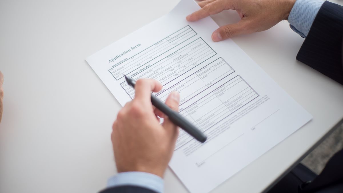 Close-up of a business professional reviewing an application form at a desk