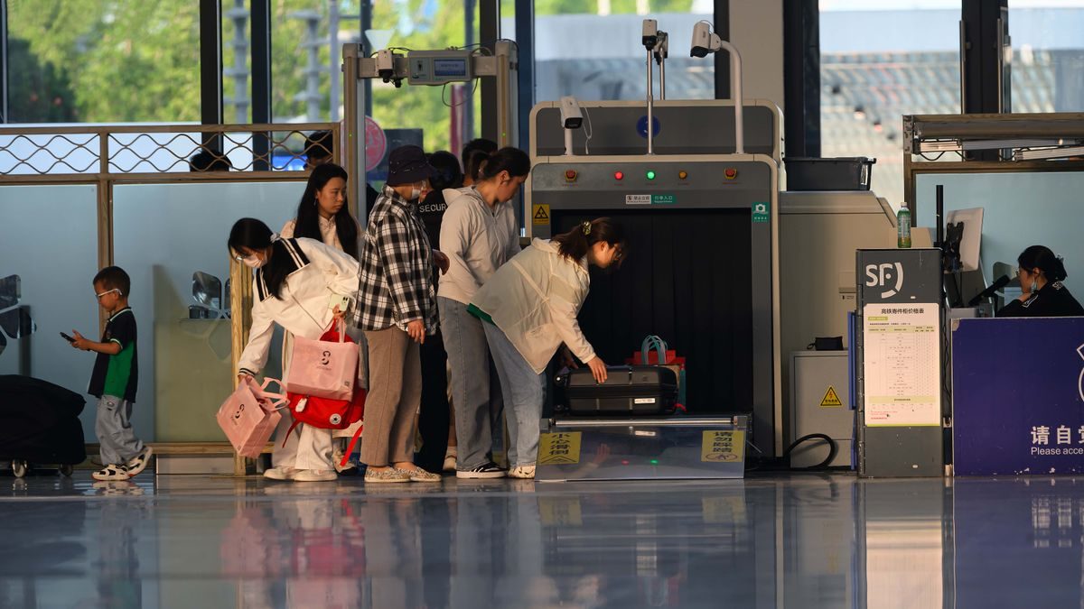 Travelers undergo security screening at an airport terminal